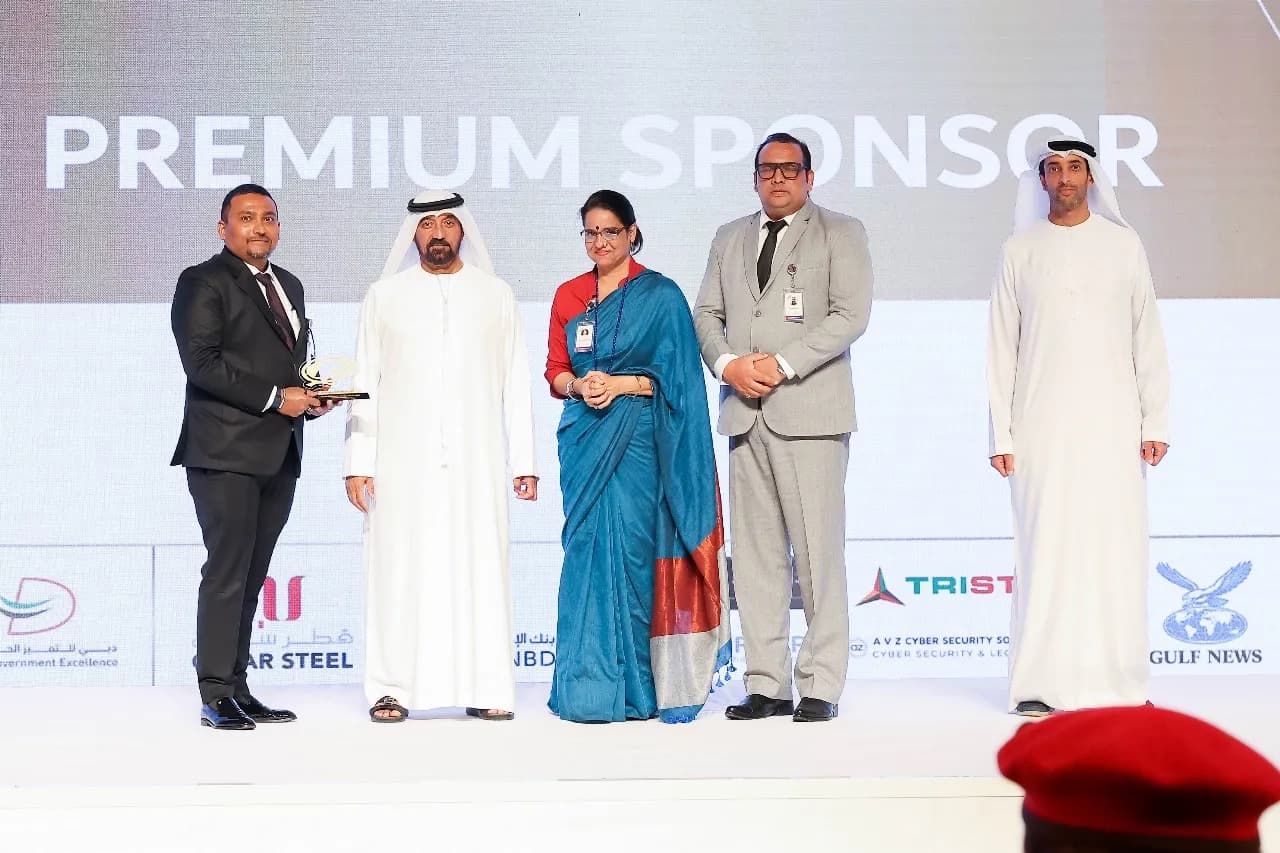 Five people on stage in front of a Premium Sponsor backdrop carrying the AVZ logo
